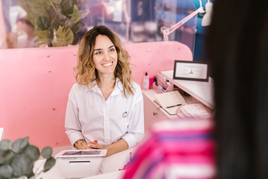 Salon receptionist smiling at desk